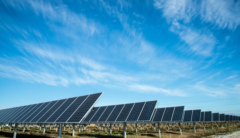 Eine Solarpark-Anlage mit einer Vielzahl an Solarmodulen, die in Reihen auf einer Wiese aufgestellt sind
